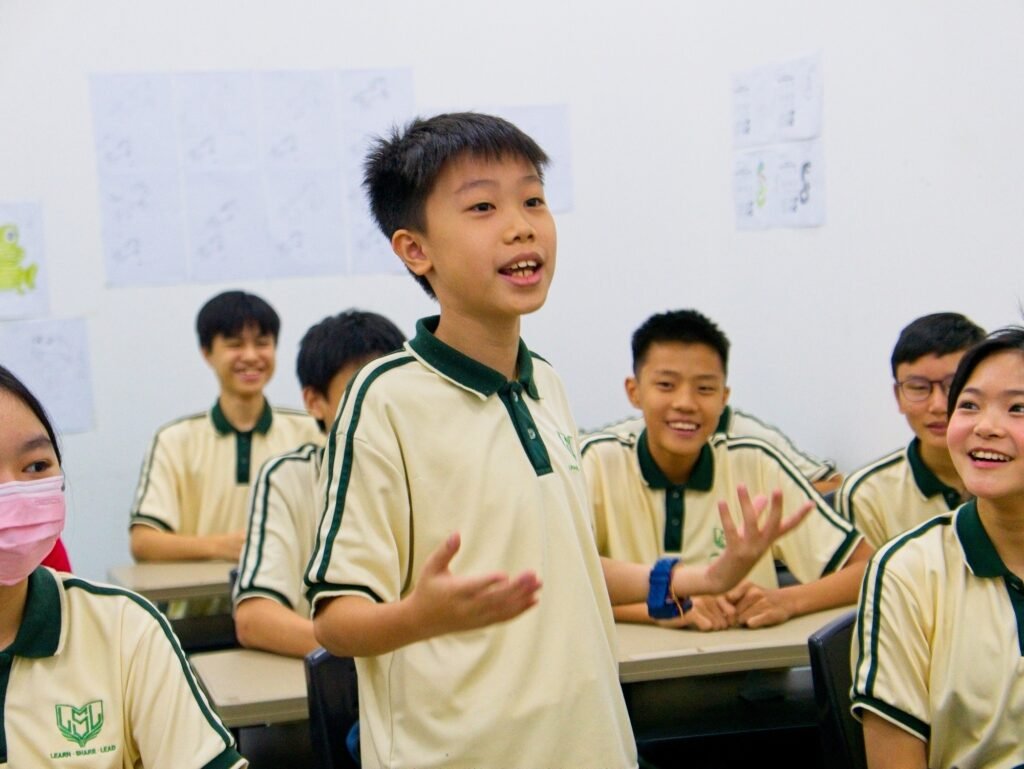 A secondary international school student confidently sharing his thoughts in class